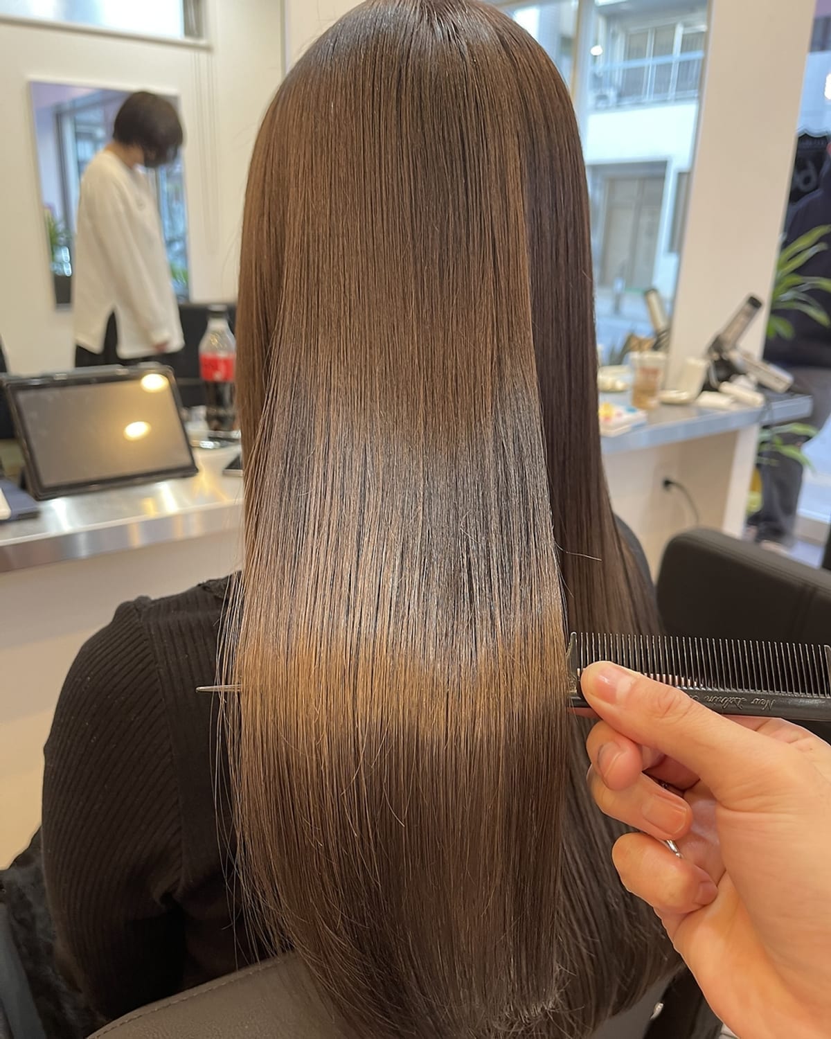 トリートメント後の髪。まとまりのあるロングヘアにコームを通した状態